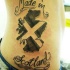 Tatuaje de bandera escocés y inscripción en el costado