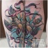 Tatuaje de pájaro hermoso de varios colores con cinta