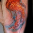 Tatuaje en el muslo,  medusa linda de color brillante