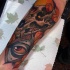 Tatuaje en el antebrazo,
 cráneo de animal con hojas y ojo misterioso
