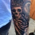 Tatuaje en el antebrazo, esqueleto de rey en corona estupenda