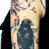 Tatuaje en el brazo, dos cuervos realistas en la rama