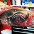 Monster bloody shark with sharp teeth in bloody waves colored tattoo on biceps in old school style