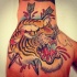 Tatuaje en la mano, 
tigre feroz perforado por flechas, estilo old school
