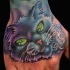 Tatuaggio carino sul mano il gatto con gli occhi verdi