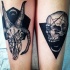 Mysterious black ink arms tattoo of demonic goat skull with human skull