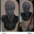Mystical black ink thigh tattoo of human like statue