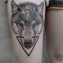 Mystical Engraving style wolf head tattoo on thigh stylized with human hear and black triangle
