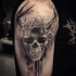 Mystical looking black ink shoulder tattoo of human skull with horns and birds nest