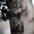 Tatuaggio mistico colorato del braccio superiore del lupo nella foresta con gli occhi gialli