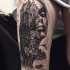 Natural looking black and white thigh tattoo of castle on rock with woman portrait