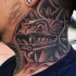 Natural looking black and white tribal statue tattoo on neck