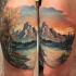 Natural looking colored tattoo fo beautiful mountains with lake