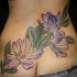 Natural looking colored waist tattoo of violet flower with leaves