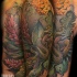 Natural looking detailed snake in forest tattoo on shoulder combined with bats and night butterfly