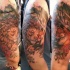 Natural looking funny sleeping lion and fox tattoo on shoulder combined with flowers and trees