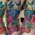 Natural looking very detailed colorful skull tattoo on side with butterfly and snake