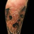 Natural looking very detailed leg muscle tattoo of corrupted human skull