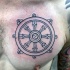 Neat dark black sailor's helm detailed chest tattoo