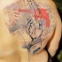 Neo traditional style colored back tattoo of human hand with paper