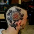 Neo traditional style colored head tattoo of beautiful flower with leaves