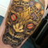 Neo traditional style colored thigh tattoo of demonic mask