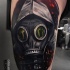 Neo traditional style colored thigh tattoo of man with gas mask
