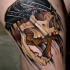 Neo traditional style colored thigh tattoo of human skull with head bandage