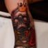 New school style colored arm tattoo of scary human skull with crown and roses