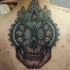 New school style colored back tattoo of human skull stylized with feather