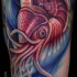 Nice detailed multicolored leg tattoo of cool squid in waters