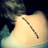 Tatuaje a lo largo de la columna vertebral, escrito hebreo vertical