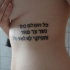 Tatuaje de texto hebreo en las costillas