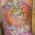 vecchio cartone stile colorato zucca malvaggia con le ossa tatuaggio su braccio