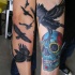 Tatuaje en el antebrazo,
bandada de cuervos con calavera de azúcar