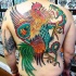 Tatuaje en la espalda,
gallo abigarrado maravilloso que lucha con serpiente