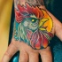Oldschool mehrfarbiges Hand Tattoo mit wütendem Hahnkopf