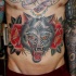 Old school style colored belly tattoo of wolf with roses