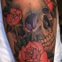 Old school style colored large leg tattoo of human skull with roses