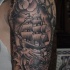 Old school style colored shoulder tattoo of sailing ship portrait stylized with flowers and anchor