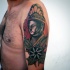 Old school style colored shoulder tattoo of Buddha statue with flowers