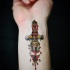 Old school style colored wrist tattoo of bloody fantasy dagger