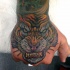Old school style naturally colored furious tiger's head tattoo on hand