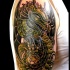 Tatuaje en el brazo, dragón verde amenazante, estilo old school