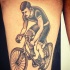 Tatuaje en el muslo,  ciclista en el bicicleta, estilo viejo simple