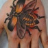 scarabeo volante arancione tatuaggio sulla mano
