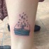 Tatuaje en la pierna, pila de libros con letras volantes