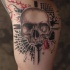 Photoshop style colored biceps tattoo of human skull with various ornaments