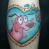 Pink cartoon dog in heart shaped frame bright colored tattoo with flowers