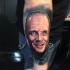 Portrait style colored arm tattoo of Hannibal Lector face